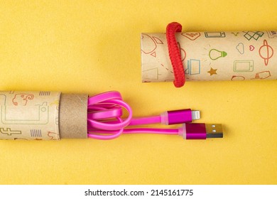 Usb Lightning Pink Data Cable In A Cardboard Tube Close-up On Yellow Isolated, Space For Text