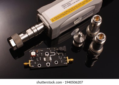 USB Microwave And RF Average Signal Power Meter For Precise Measurements And RF Amplifier PCB Under Test Isolated On The Black Background