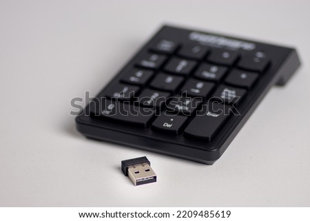 A USB receiver for a wireless numeric keypad, isolated on a white background.