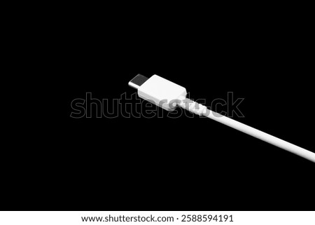 USB Type C cable isolated on black background. Mobile phone charging cable. White Type C cable for charging a smartphone isolated