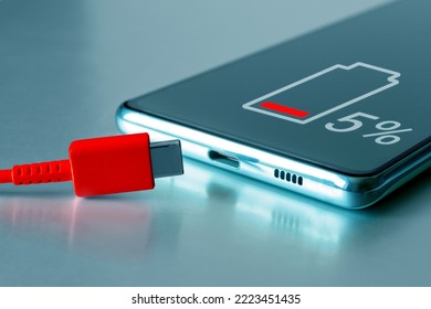 USB Type-C Cable And Smartphone. Discharged Smartphone With Low Battery Icon And Red Charging Type C Cable. Dangerously Low Charge, Fast Battery Wear And Tear, Urgent Quick Charge.