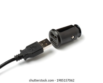 USB wire and black car charger with two USB ports, multifunctional cigarette lighter adapter plug. white background. copy space.