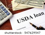 USDA loan form and documents on a table.
