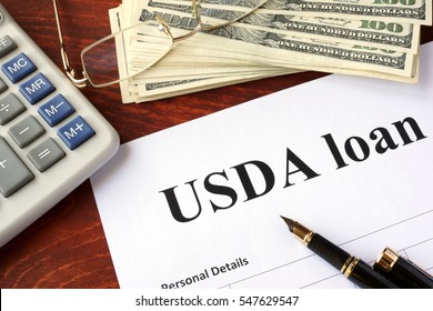 USDA loan form and documents on a table.