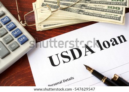 USDA loan form and documents on a table.