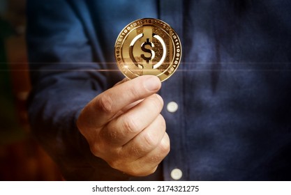 USDC USD Coin stablecoin cryptocurrency golden coin in hand abstract concept - Shutterstock ID 2174321275