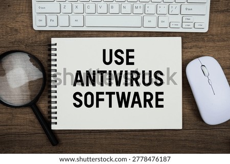 Use Antivirus Software text written on notepad with keyboard, optical mouse and magnifying glass on wooden background;