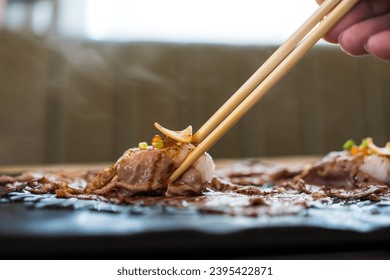 Use chopsticks eating A5 grade Japanese wagyu beef sushi. Eating wagyu beef sushi in lunch time - Shutterstock ID 2395422871