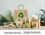 Use of eco-friendly paper tableware and packaging made from biodegradable materials. Set of eco friendly food packaging with recycling symbols on table white background.
