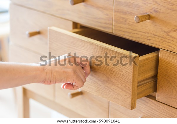 Use hand pull\
open drawer wooden in\
cabinet.