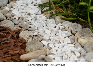 the use of natural materials in landscape design. Pine bark, white stones and pebbles as decoration of the green area in the city.