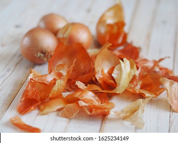 The use of onion skins in medicine and for coloring Easter eggs. Onion skin and onion on a wooden background.