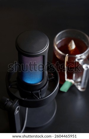 Use this cozy setup image to showcase remote work or live streaming scenarios, blending the warmth of tea breaks with professional audio production. Photo. Selective focus