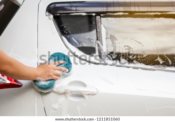 Use your right hand to catch the sponge\
and polish the car window. Concept car\
wash.
