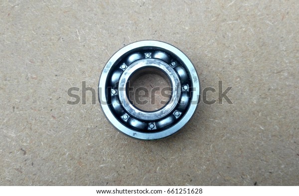 Used bearings the mechanical\
components of car engines isolated on the high-pressure timber\
board. 