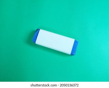 Used Blue Eraser with white cover Top View Isolated on Green Background.