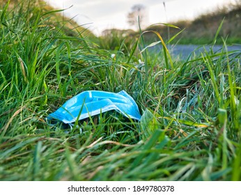 A Used, Blue Surgical Mask Used For COVID-19 PPE Protection, Discarded As Litter In Rural Countryside