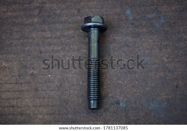 a used bolt with\
lubricant oil on paper
