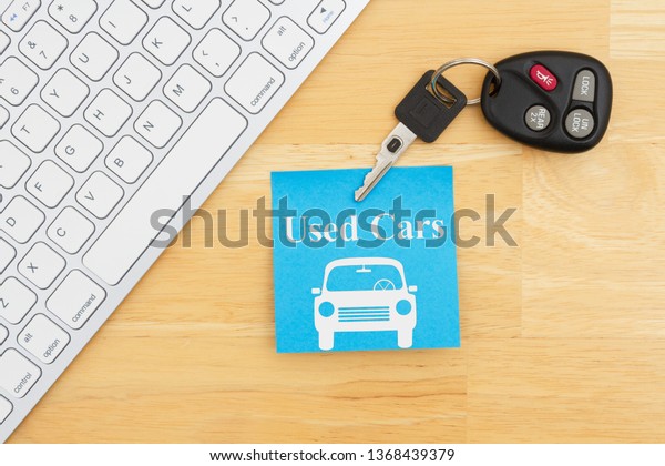 Used car message\
with car keys with a keyboard on a sticky note for your finding\
used vehicles online\
message