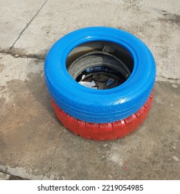 Used Car Tire Red And Blue Colour Lying On Dirty Floor.