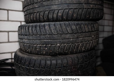 Used car tires against a brick wall. Worn tread of winter tires - Powered by Shutterstock