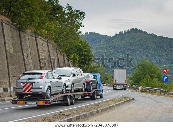 Used car\
transport.A small truck transports cars on a car platform. Romania,\
Severin. September, 17,\
2021