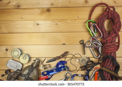 Used Climbing Gear On Wooden Background. Advertising Boards Of Trade. The Concept Of Extreme Sports. Decoration Of Older Equipment Climbers