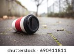 Used Coffee mug at sidwalk as symbol for pollution.