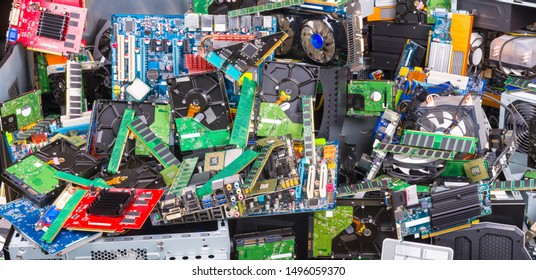 Used computer and laptop parts for e-waste recycling. Large colored heap of electronic, plastic and metal refuse from old discarded or obsolete PC components. Ecological danger. Full depth of field.