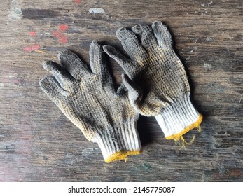 Used Construction work gloves, dirty glove on a wood background photo