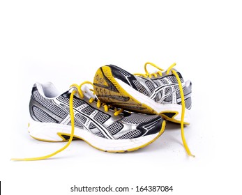 Used Dirty Pair Of Running Shoes Over A White Background