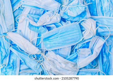 Used disposable medical masks background. Medical waste. Garbage and the environmental impact of the covid-19 coronavirus pandemic. Ecology concept. - Shutterstock ID 2105287790