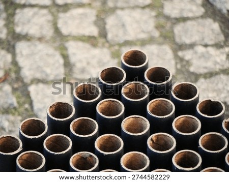 used and empty pyrotechnic cake firework launcher with long tubes on ground of a pavement