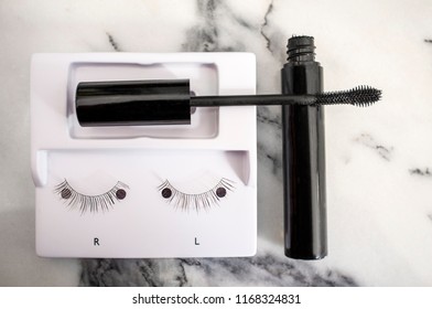 Used False Eyelashes And Mascara Applicator Over Bathroom Marble Counter. Overhead Shot