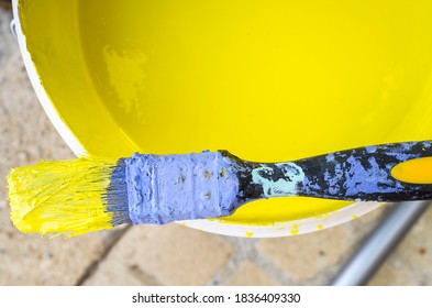 Used flat decorator brush  covered with dry blue chalk and wet yellow color. Closeup - Powered by Shutterstock