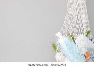 Used Hygiene Products In A Mesh Bag On A Gray Background. Trash With Used Cosmetics Plastic Packaging. Conscious Consumerism 