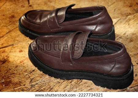 used leather shoes with an elegant brown look on a simple wooden table