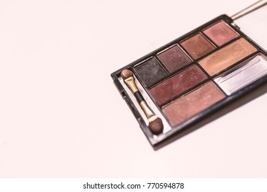 Used Make-up Box With Make Up Brush. Old And Used Cosmetic Set Isolated On The White Background. Eye Shadow Palette In Rose Gold And Nude Colors Closeup. Makeup Cosmetics. Selective Focus.