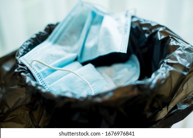 The Used Mask Is Cut To Prevent Reuse In The Bucket. Close Up Of Used Face Masks, Medical Face Masks. Useless Coronavirus Face Mask.