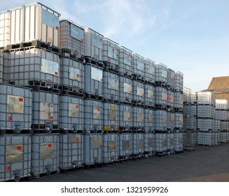 used metal framed intermediate bulk containers stacked on pallets waiting to be cleaned or recycled in an industrial yard - Shutterstock ID 1321959926