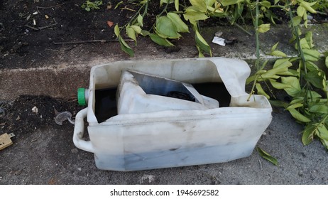 Used Motor Oil Abandonned On The Sidewalk In Half Cut Plastic Cans