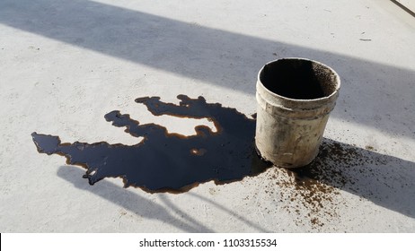 The Used Oil Spill From A White Bucket On The Floor.