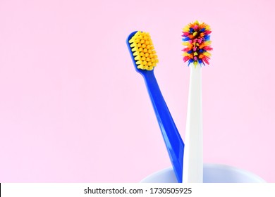 Used Old Toothbrush With Disheveled Colorful Bristles And New Tooth Brush With Selective Focus On Pink Neutral Background, Copy Space. Replace An Old Toothbrush With A New. Old And New Toothbrushes 