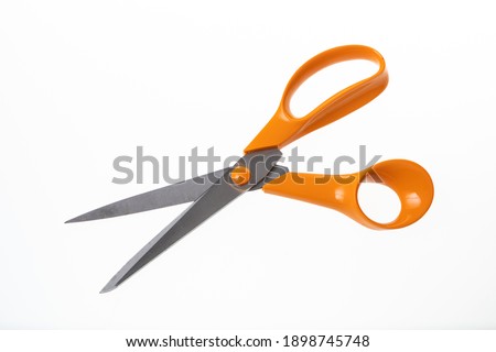 Used orange scissors on a white background 