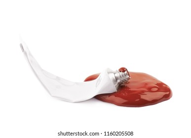 Used Paint Tube Lying In A Dye Spill Splash, Composition Isolated Over The White Background