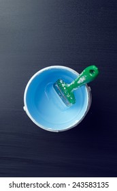 Used Paintbrush In A Paint Bucket Over Dark Background, Above View