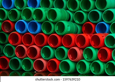 Used Plastic Barrels. Blue, Green, And Red Plastic Drum. Stacked Of Empty Tank In Food Factory Waiting For Recycle And Reuse. Container Of Raw Material In Food Manufacturing Industry. Old Plastic Drum