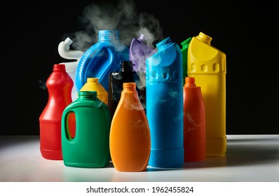 Used Plastic Bottles With Smoke Over Dark Background. Household Cleaning Product. Global Warming Problem Conception. Poisoning Air And Ocean Problem