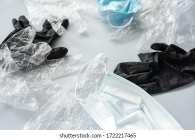 Used Plastic Gloves And Medical Masks On A Gray Background, Top View. The Effects Of Quarantine Coronavirus, Plastic Trash.