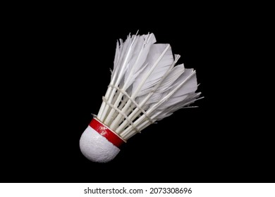 Used shuttlecock that has been broken on a black background